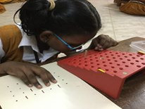 A child with low vision using a tactile cue card to solve a puzzle