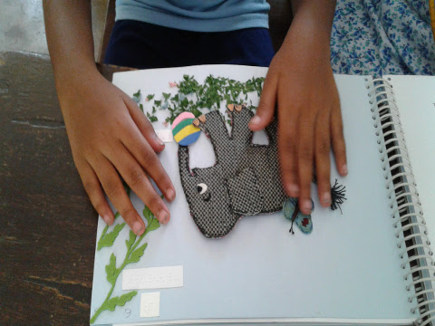 A young girl explores a page from ‘Baby Elephants Day Out’ - an accessible tactile book.