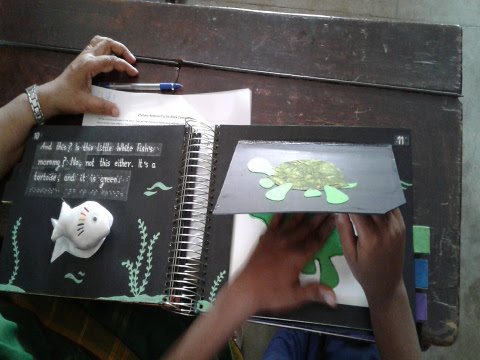 A young boy explores a page from ‘Little White Fish’ - an accessible tactile story book.
