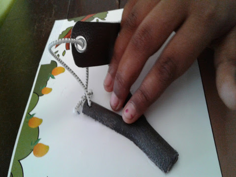 A young girl touches a mini catapult which is attached to an accessible tactile book